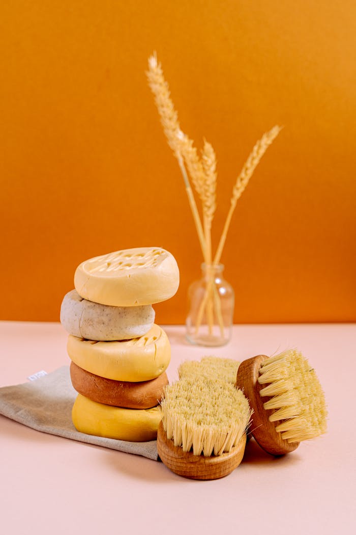about-img Aesthetic composition of stacked organic soap bars and natural brushes on a minimalist setup.